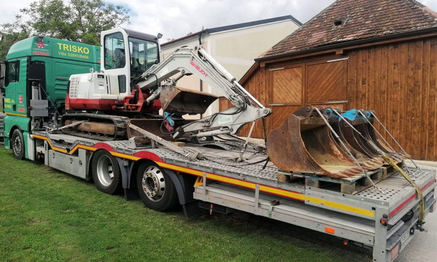 unser Abschlepptransporter mit einem Bagger auf der Ladefläche